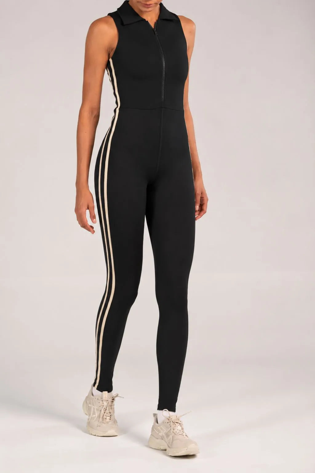 Jumpsuit deportivo largo negro con cuello, cremallera y franjas laterales crema