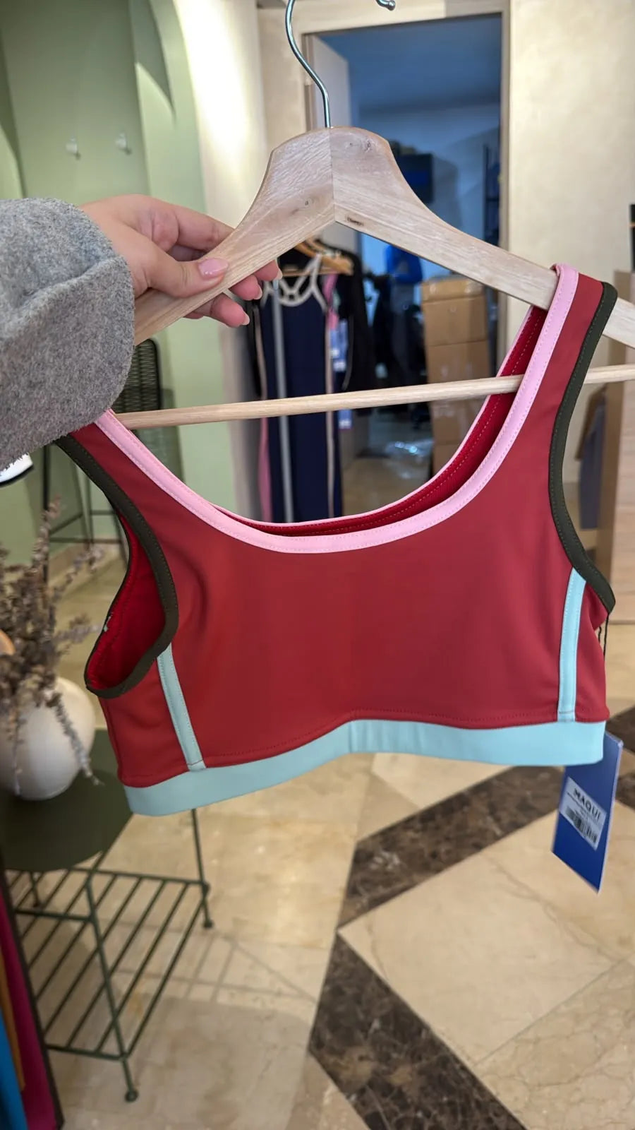 Sports bra rojo con ribetes rosa, oliva y menta
