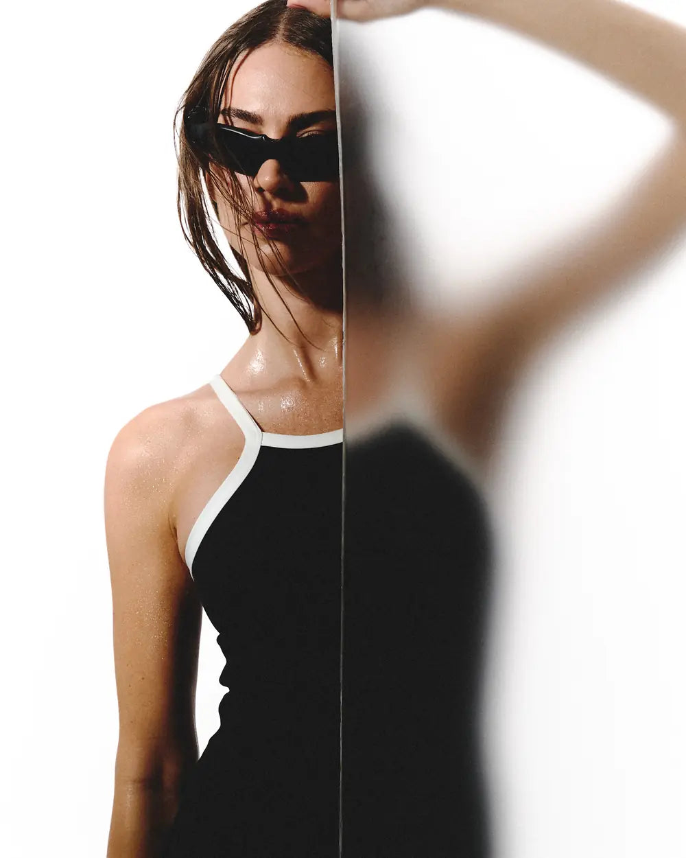 Modelo con enterizo negro detrás de un vidrio