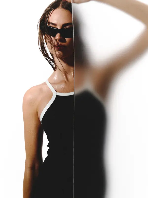 Modelo con enterizo negro detrás de un vidrio